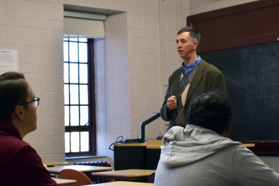 Man stands at front of classroom
