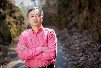 Shuhai Xiao standing on a path with rock walls behind him