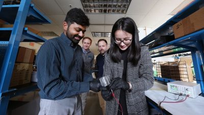 (From left) Ravi Tutika, Michael Bartlett, Josh Worch, and Meng Jiang test the recyclable circuit created by the teams from mechanical engineering and chemistry. Photo by Alex Parrish for Virginia Tech.