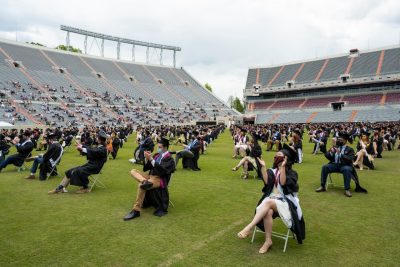 seated, clapping seniors celebrate a social distanced graduation in Lane Stadium