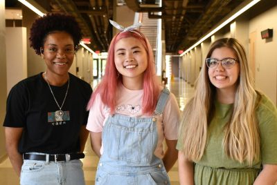 three female students stand in hallway of chemistry building