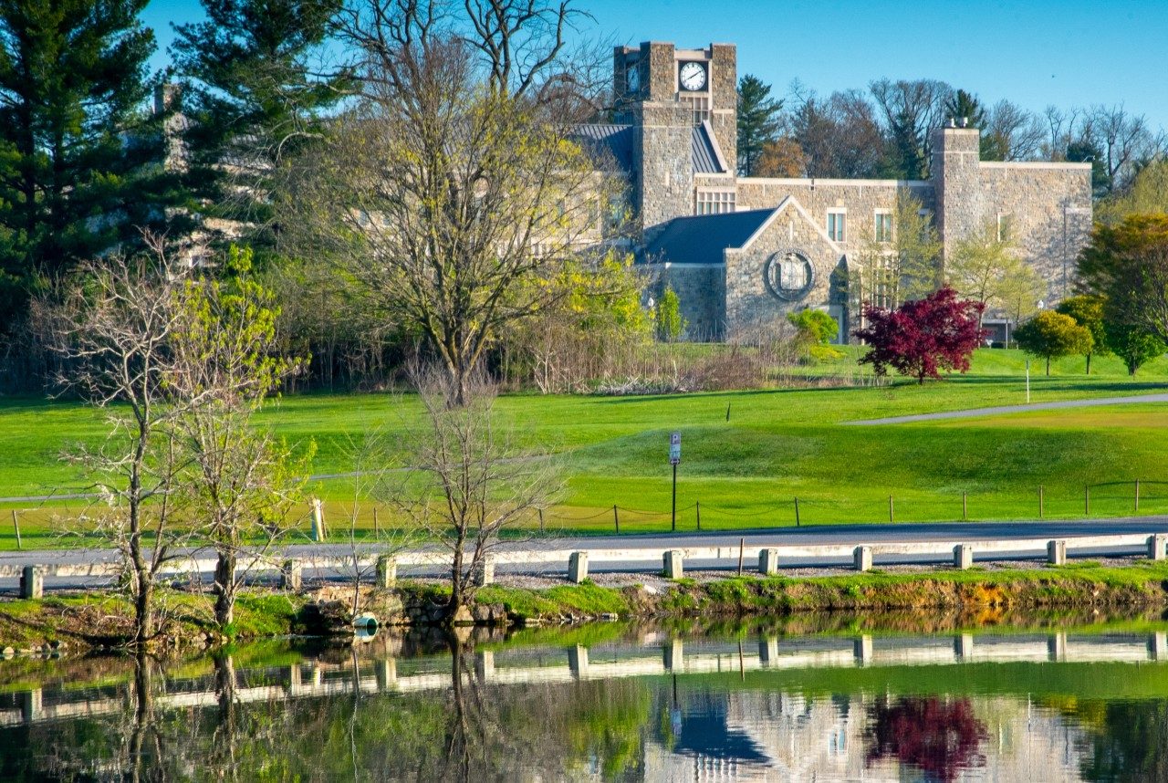 alumni hall reflecting in the duckpond in early spring