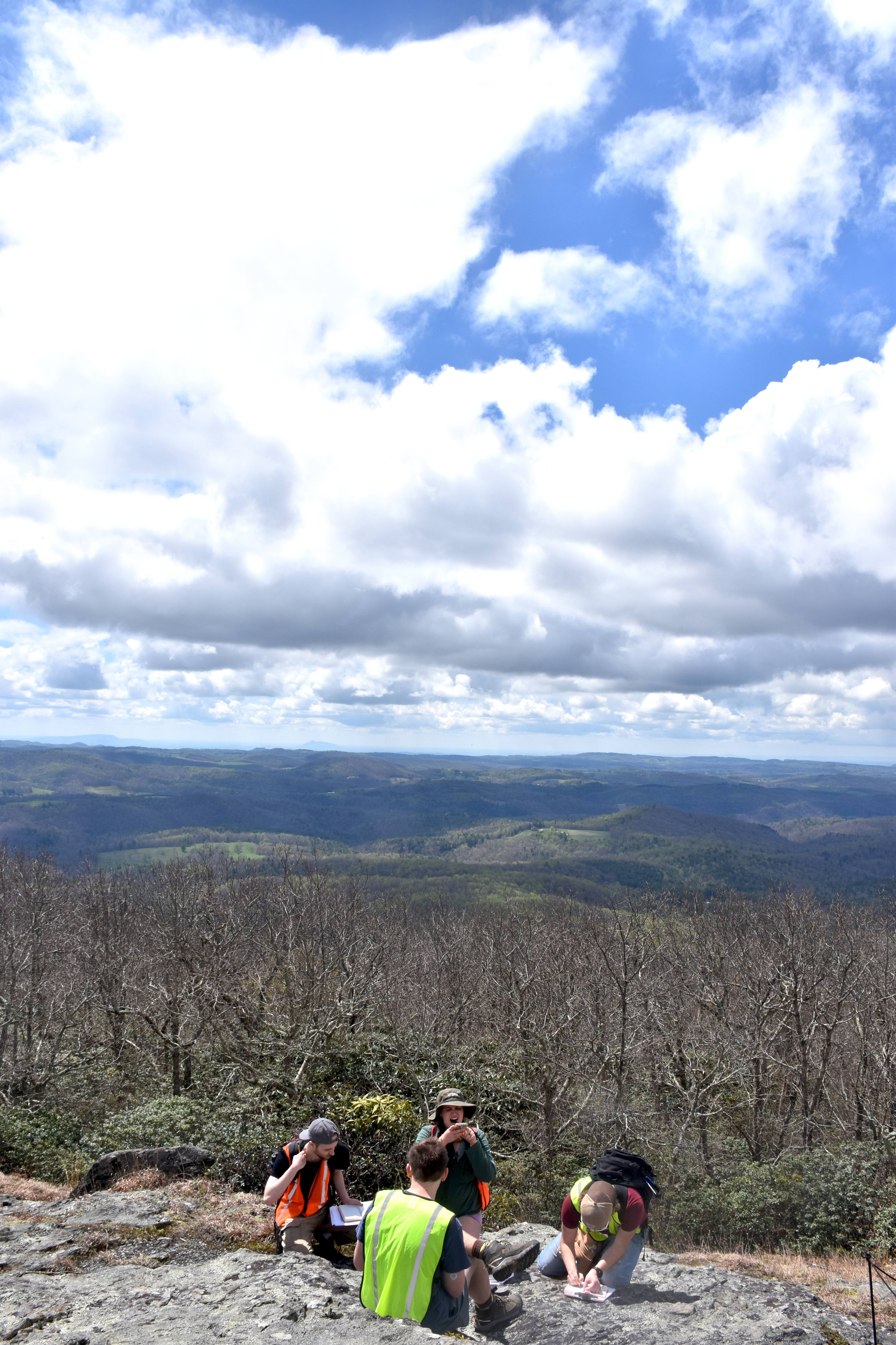 students on mountain top with notepads