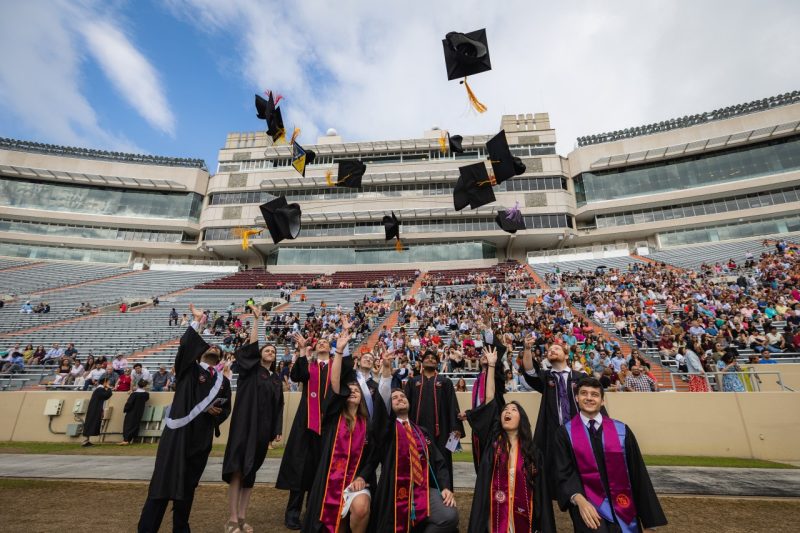 group of recent graduates throw their caps in the air