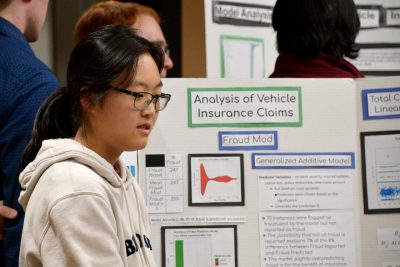 Student stands next to poster.