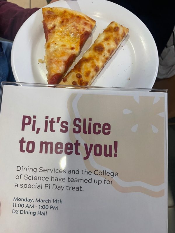 A piece of pie sits on a plate, below it is a sign saying, "Pi, it's Slice to meet you" and the date  of Monday, March 14, 2022.