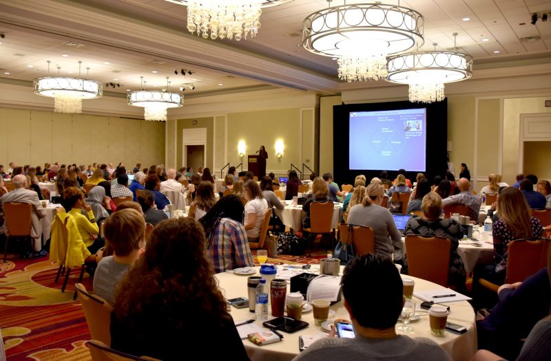 Angela Scarpa speaking at podium to Autism Symposium room