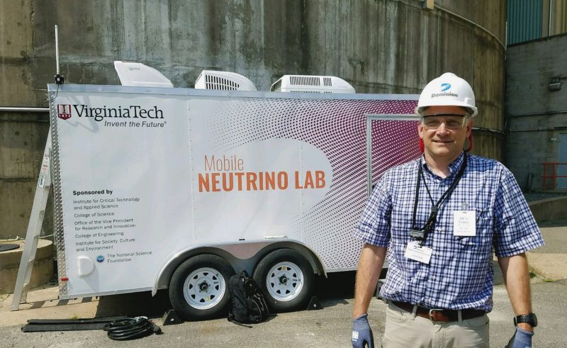 Link with hardhat in front of mobile neutrino lab trailer at North Anna power plant