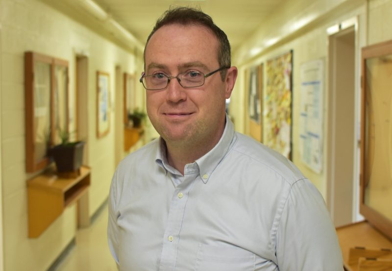 Thomas O'Donnell standing in a hallway in the Physics building at Virginia Tech