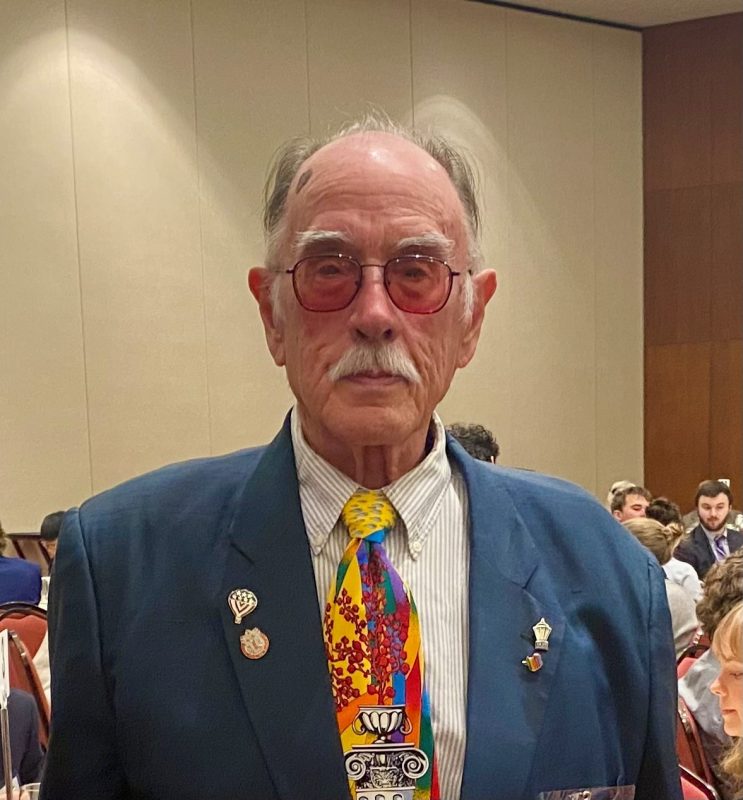 portrait of man with glasses and jacket with pins