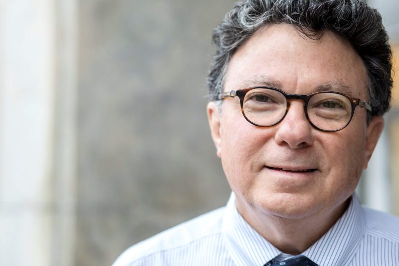 portrait of man with glasses and graying, curly hair