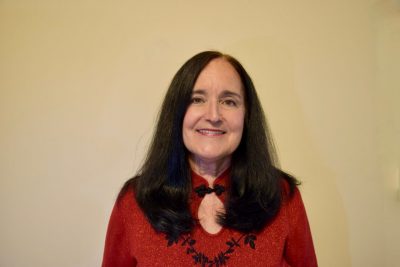 portrait of woman with long brown hair and red shirt