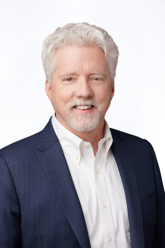 portrait of man with white hair in business attire 