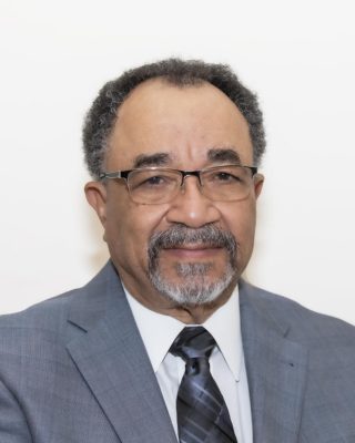 man with glasses, gray blazer and graying beard