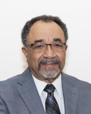 man with glasses, gray blazer and graying beard