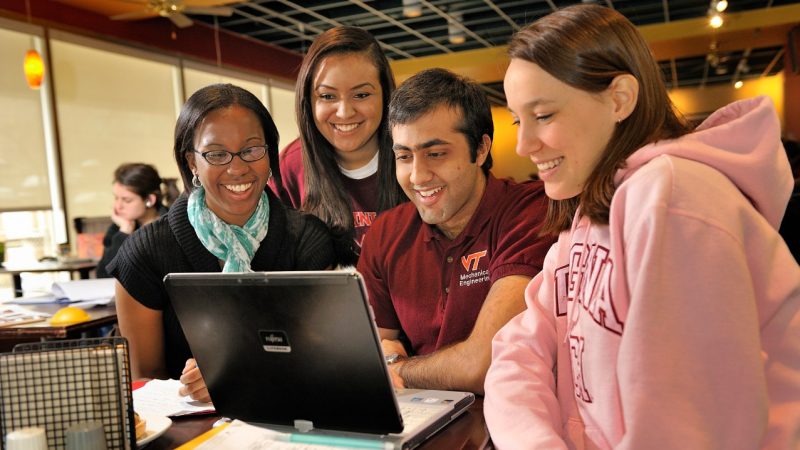 students gather around a computer