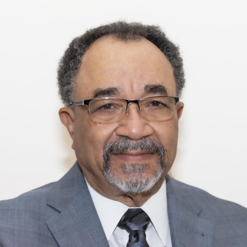 man with glasses, gray blazer and graying beard