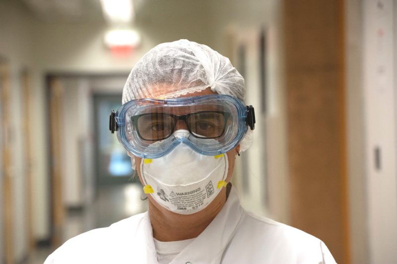 Finkielstein wears mask, lab coat, and hair net and looks at camera.