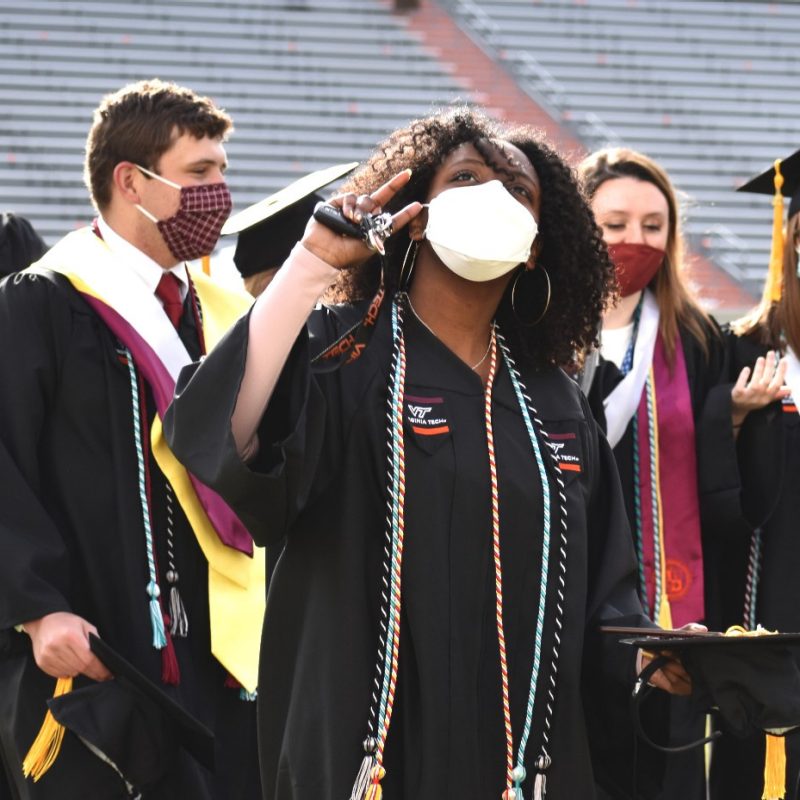 graduating seniors mingle and wave inside Lane Stadium