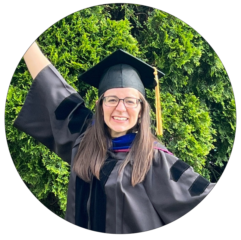 young woman in graduation grab poses in with arms stretched out
