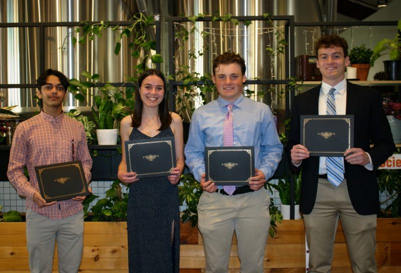 Four students hold certificates.