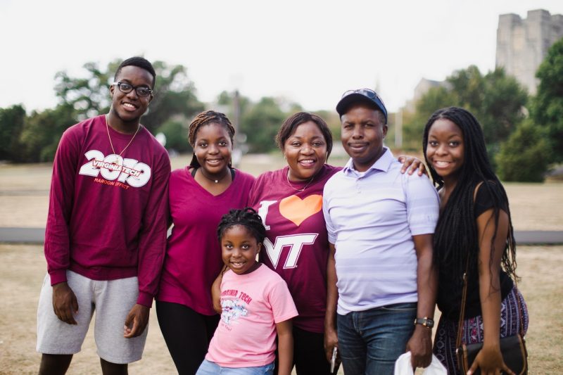 family of 6 poses on drillfield in Virginia Tech apparel